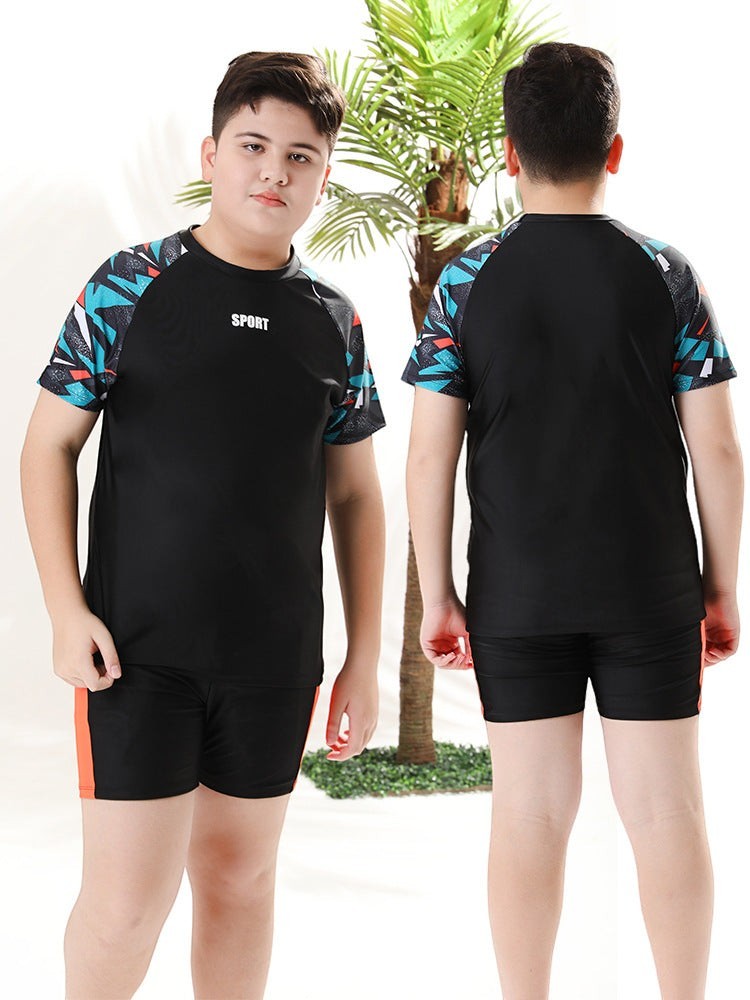 Creative Vault Marketplace boys two-piece black swim set with geometric sleeves and matching trunks on a young boy